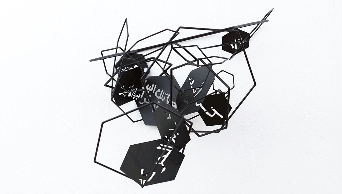 A metal geometric sculpture made up of black hexagonal shapes entwined together.