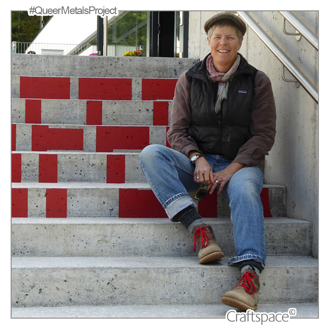 a person sits on some grey steps with red lettering on.