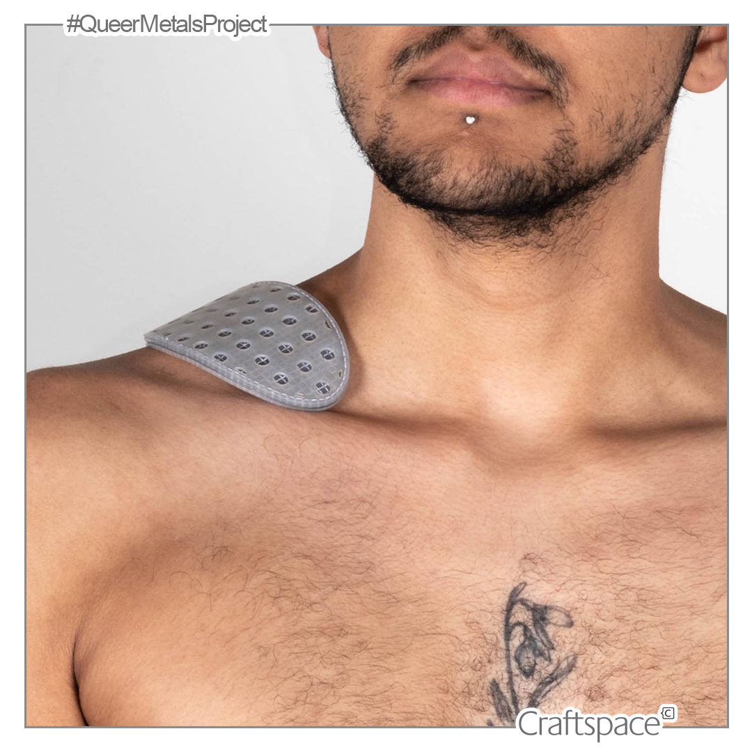 section of a person's torso visible with a grey perforated piece which rests on their collarbone