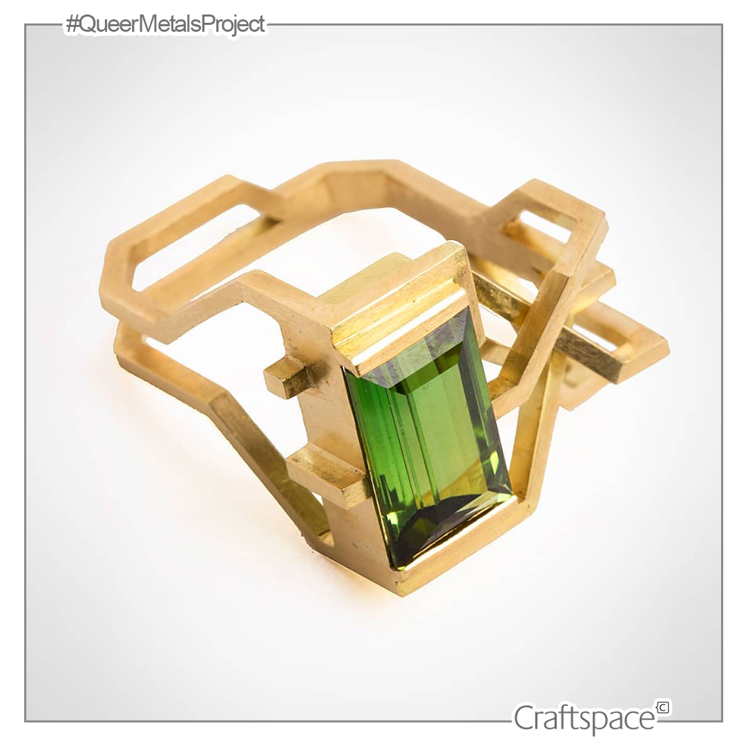 bright green faceted stone set into a maze of yellow gold to create a sculptural ring