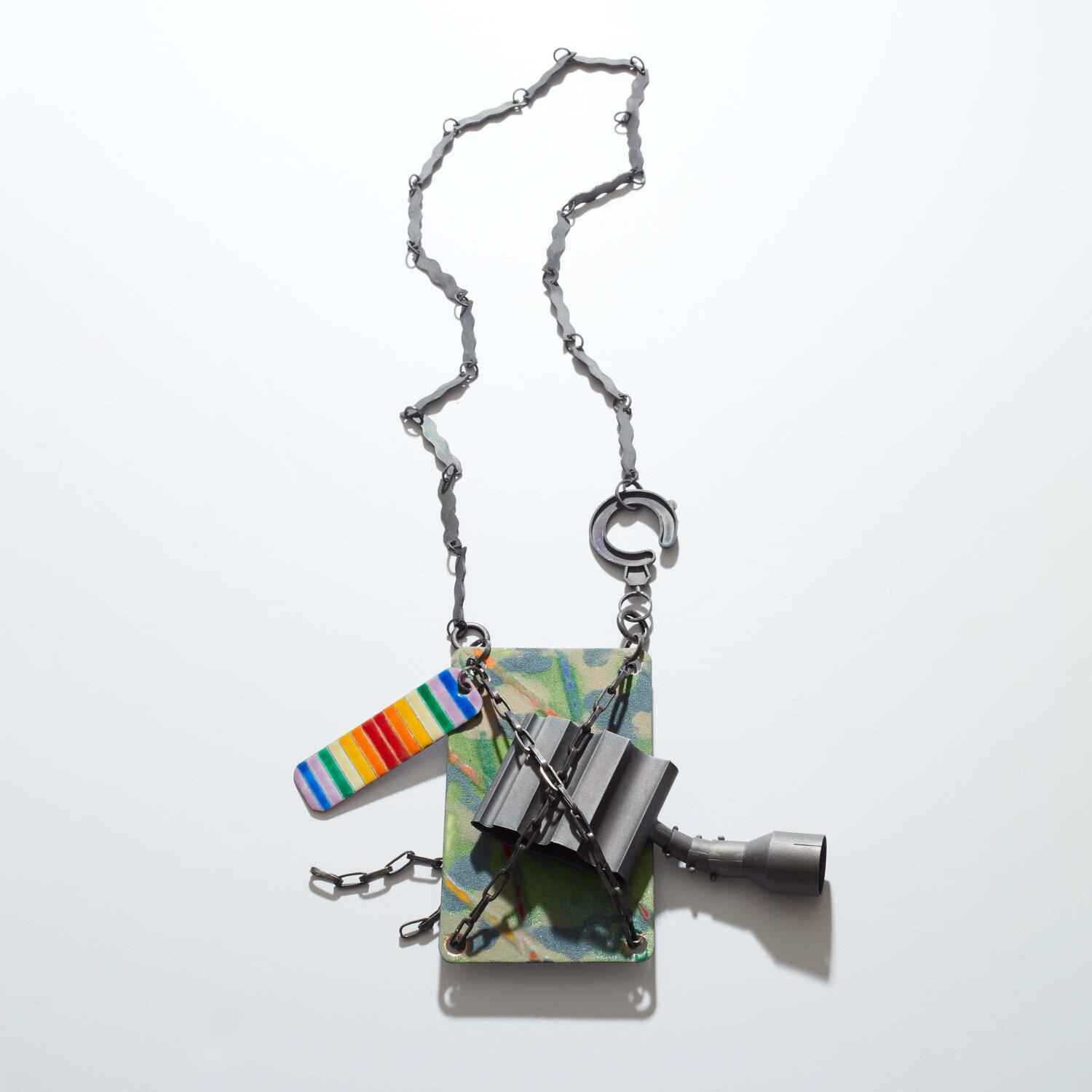 Necklace composed of brightly coloured metal pieces hang on a grey linked chain