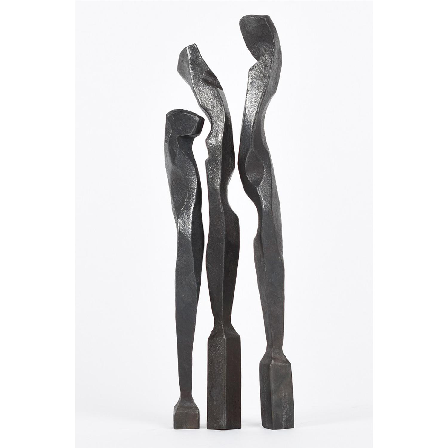Three forged columns of steel, forged to evoke bodies seen against a white background; they seem to be in conversation, subtly interacting through gesture