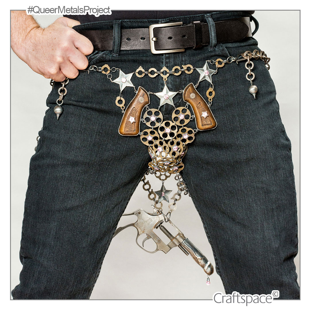 Image of metal gun deconstructed and coneected with silver and bronze chain links worn around the waist as a belt with the gun hanging down