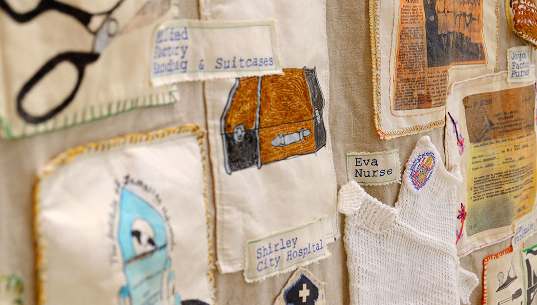 Sections of material on a wall hanging show a suitcase, some scissors. Text says 'Shirley, City Hospital' and 'Eva Nurse'.